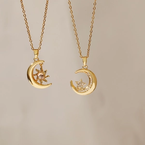 Detail of gold crescent moon necklaces with pink and white zircon stone star accents