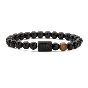 Tiger eye and black agate beaded bracelet featuring a Virgo zodiac sign charm on white background