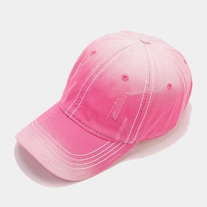 Detail view of pink gradient cotton baseball cap with vintage distressed texture and stitching