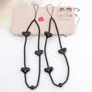 Handmade black beaded phone wrist strap set featuring polished heart charm decorations