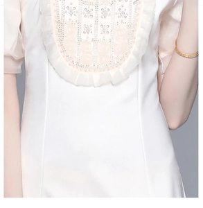 Détails de broderie de perles lourdes et de volants délicats sur une robe blanche