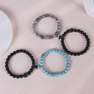 Detail view of magnetic couples bracelets with crown charms and natural stone beads