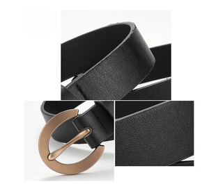 Detail of slim black leather belt showing golden circular buckle and fine grain texture