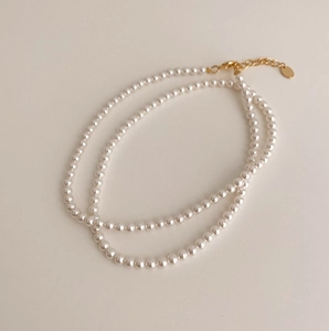 Close-up of double layer pearl necklace with golden lobster clasp and extender chain