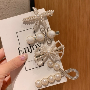 Detail view of 4-piece pearl and rhinestone hair clip set with starfish and bow designs