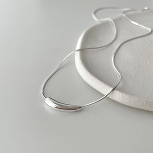 Detail of a 925 sterling silver snake chain necklace with a minimalist teardrop pendant