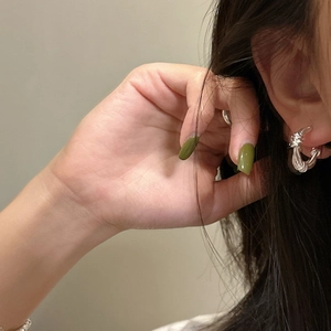 Elegant S925 sterling silver twisted knot stud earrings worn by a model in a close-up view