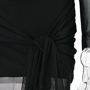 Vue détaillée de la texture du tissu en maille et du nœud à la taille de cette robe noire