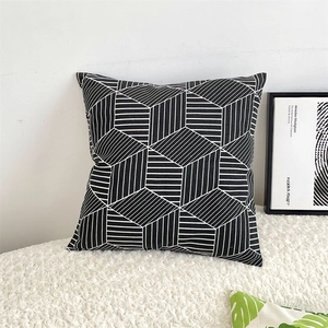 Detail of a square cushion cover featuring a 3D black and white geometric cube pattern