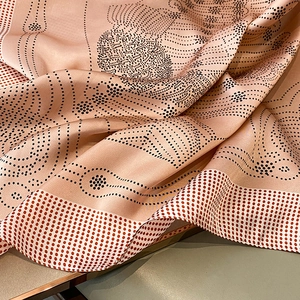 Macro shot of pink silk scarf showing smooth texture with black and red polka dot pattern