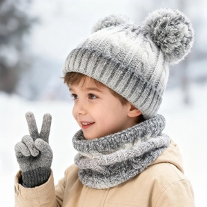 Outdoor snow scene of kids winter knitted set including hat with pom-poms, scarf and gloves