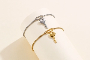 Détail macro du bracelet ajustable en titane avec pendentif cœur et clé en or et argent