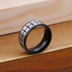 Close-up of dual-tone black and grey stainless steel ring with grid tire tread pattern