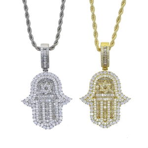 Dettaglio dei ciondoli mano di Hamsa in argento e oro con stella su catene a corda