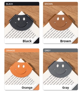 Detail of four colorful leather corner bookmarks with smiley faces on book pages