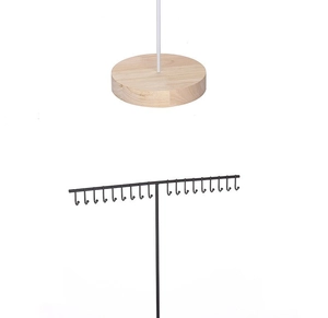 Detail view of round wooden base and black metal stand with small hooks for jewelry display