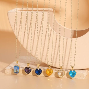 Classic glass heart and rectangle pendant necklaces with gold chains on stone base