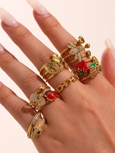 Close-up of gold insect rings featuring dragonfly and strawberry enamel details