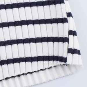 Close-up of navy and white striped ribbed knit fabric with wide elastic hemline
