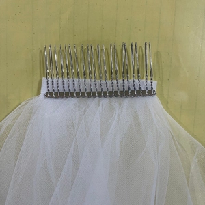 Minimalist double-layer bridal veil with metal hair comb on a light green background