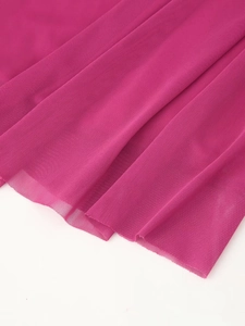 Detail shot of the fuchsia mesh fabric showing fine texture and sheer quality