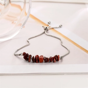 Macro detail of reddish-brown stone beads on adjustable silver box chain bracelet