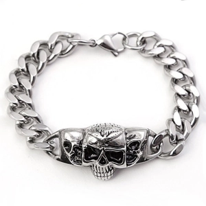 Detailed close-up of a silver punk skull charm on a polished Cuban link chain bracelet