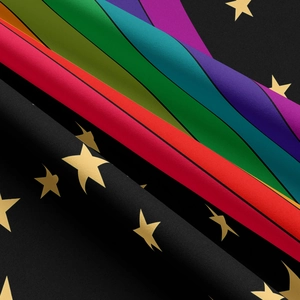 Macro detail of polyester woven fabric with gold star pattern and rainbow stripes
