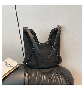 Detail of black rivet bag featuring sun moon embossing and stylish long fringe