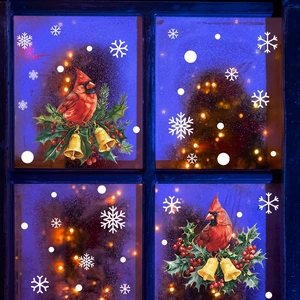 Détail de stickers de Noël avec oiseaux rouges et cloches dorées sur une fenêtre de nuit