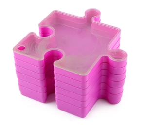 Macro view of stacked rose pink jigsaw puzzle storage trays with frosted lids