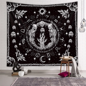 Mystic skull and zodiac tapestry in black and white hanging on a white brick wall