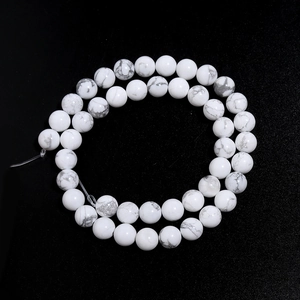 Macro view of white turquoise beads with grey marble veins in a spiral pattern