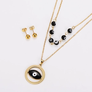 Dettaglio del set collana in acciaio dorato con perline a occhio nero e pendente