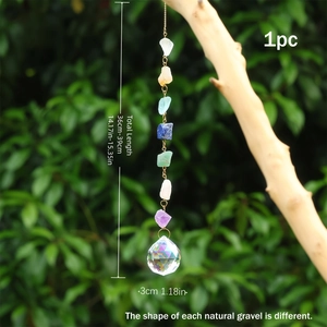 Détail d'un attrape-soleil en cristal avec pierres naturelles et boule à facettes sur branche
