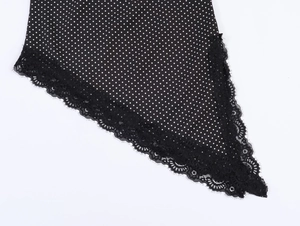 Detail of black polka dot fabric with delicate lace trim and fine stitching craftsmanship