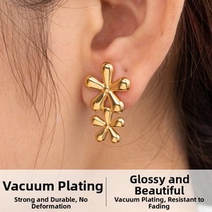 Close-up of golden five-petal flower stud earrings with a polished mirror finish on ear
