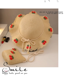 Detail view of woven straw sun hat and matching crossbody bag with crochet cherry decors