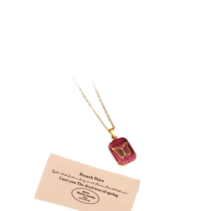 Golden butterfly necklace featuring a magenta rectangular pendant on a stylish art card