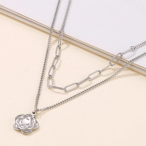 Detail of silver double-layered necklace featuring a hollow flower pendant and paperclip chain