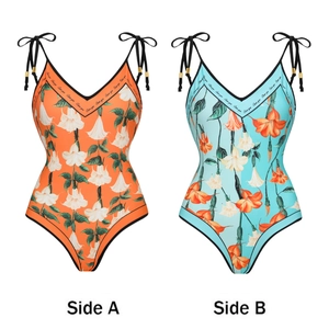 Dettaglio del costume floreale con scollo a V profondo, motivi reversibili e lacci dorati