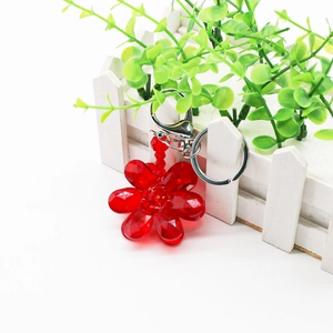 Detail of a red crystal flower keychain featuring faceted beads and silver metal keyring