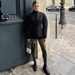 Fashionable women's black V-neck puff sleeve blazer with stylish geometric patterned tights
