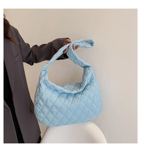 Detail of light blue quilted tote bag showing diamond stitching and puffy nylon material