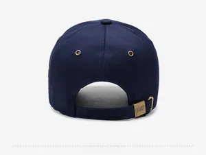 Détail de la boucle en laiton avec logo gravé sur la casquette en coton bleu marine