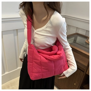 Close-up of bright pink quilted puffer shoulder bag showing soft nylon texture