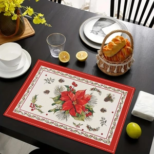 Detailed close-up of a festive linen placemat featuring red poinsettia and berry motifs