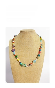 Detailed view of colorful flower glass beads and pearls on a necklace display stand