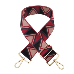 Close-up of thick geometric triangle jacquard wide strap with gold metal lobster clasps