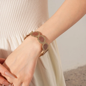 Close-up of a vintage golden chain bracelet with dark brown leopard print circular charms